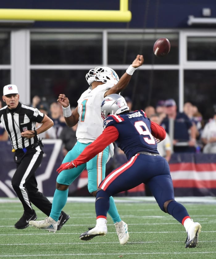 Miami Dolphins quarterback Tua Tagovailoa (1) throws the ball prior to getting hit by New England Patriots linebacker Matt Judon (9). Mandatory Credit: Bob DeChiara-USA TODAY Sports
